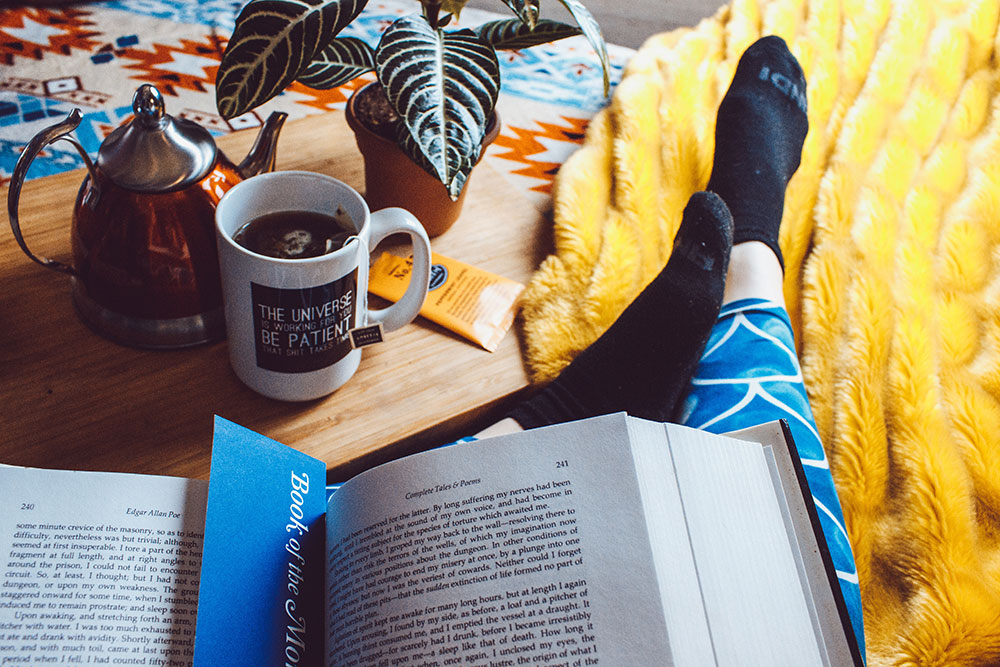 Woman reading a book with a cup of tea