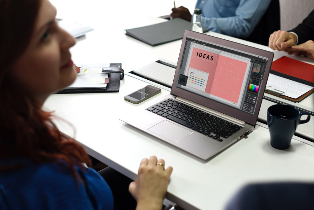 Woman talking over her laptop, which reads 'ideas'