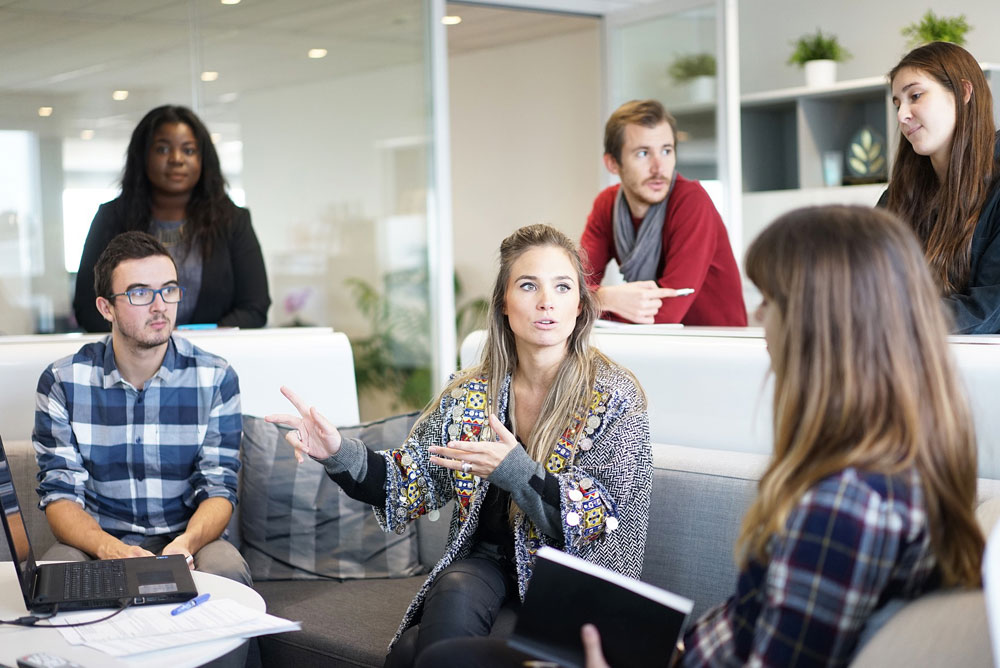 Image of a team talking around a sofa