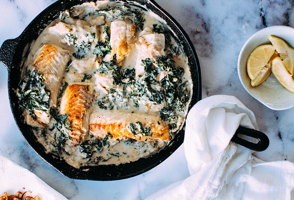 Image of salmon in creamy spinach sauce in skillet