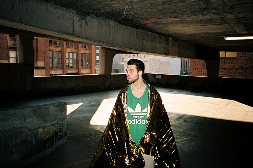 Image of male model in parking lot with blanket