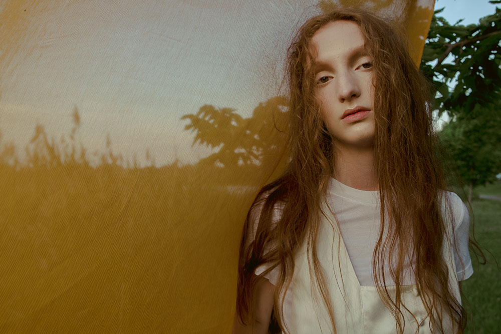 Image of female model looking into camera in feild