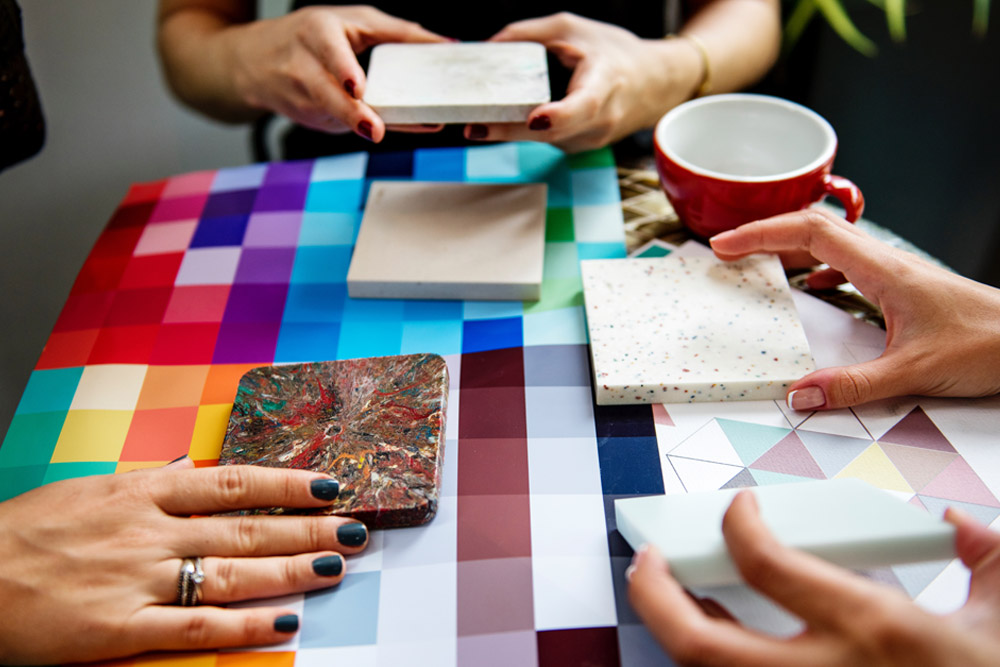 Image of hands holding different tile choices next to color swatches