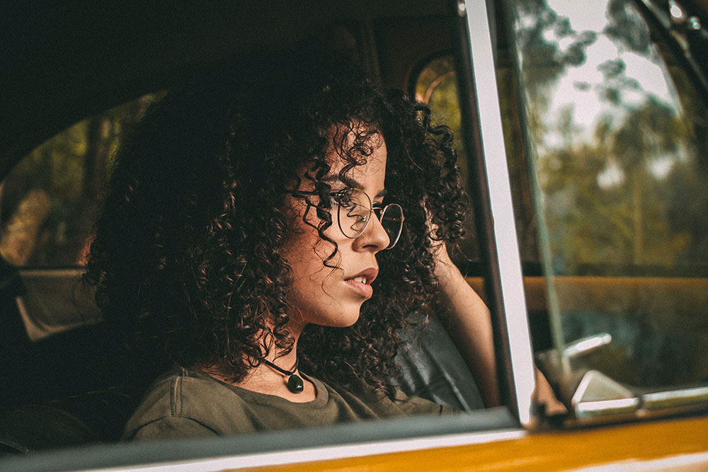 Image of a woman in her car staring at the road ahead